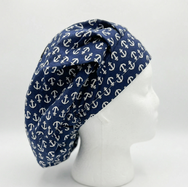 A side profile of a white mannequin head wearing a navy blue scrub cap with a white anchor pattern.