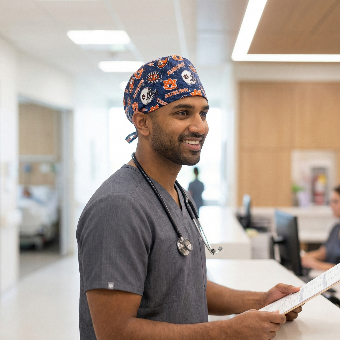 A female model in blue scrubs wearing the Auburn Tigers surgical cap against a neutral studio background.
