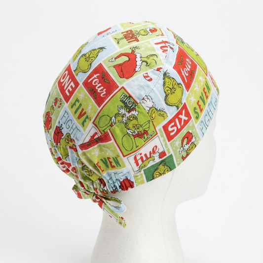 Side profile view of a surgical cap featuring a green Grinch cartoon design on a white mannequin head with adjustable tie-backs.