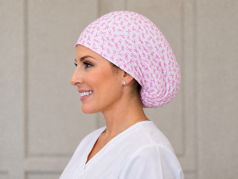 Breast Cancer Awareness pink satin-lined bonnet with ribbons, worn by a healthcare professional
