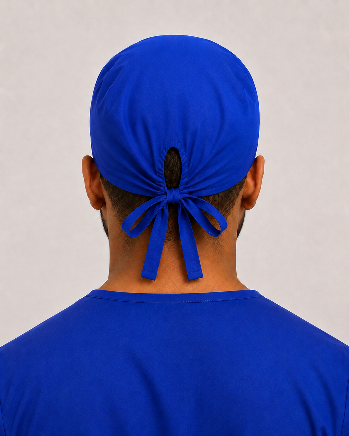 Solid royal blue satin-lined surgical cap, back view showing the tie